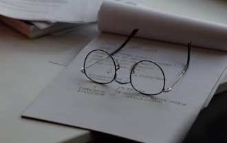 black framed eyeglasses on top of white printing paper